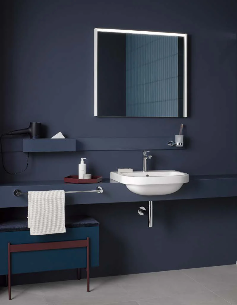 Navy blue bathroom with illuminated mirror and washbasin console
