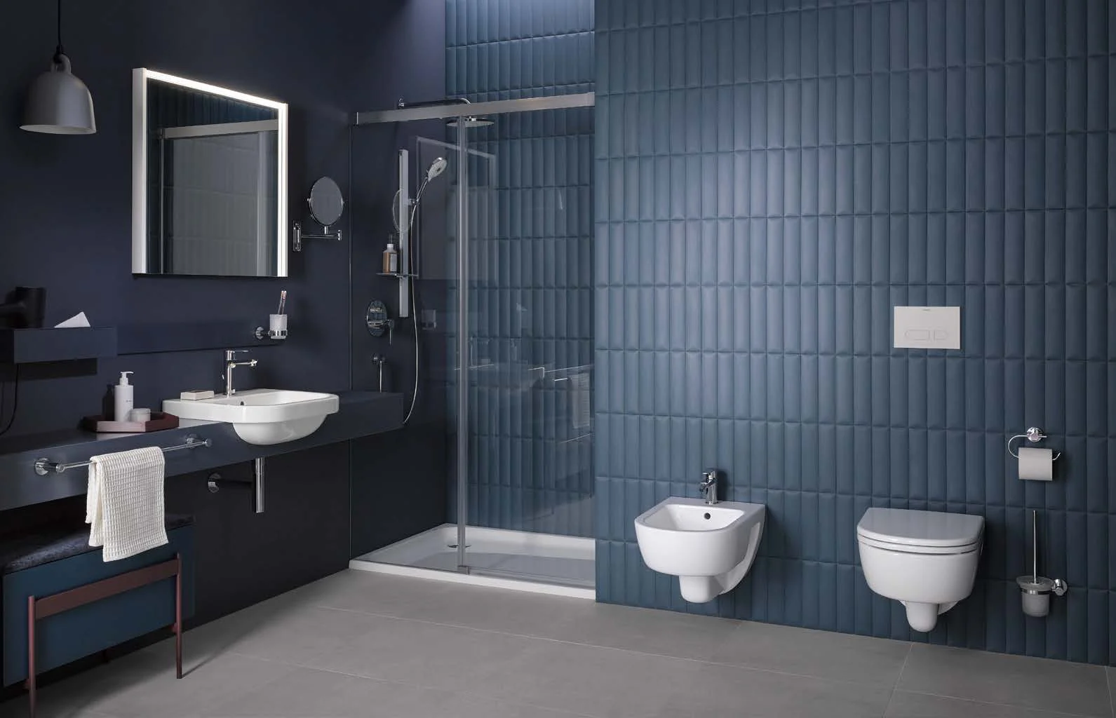 Blue project bathroom with shower, bidet and toilet at a tiled wall