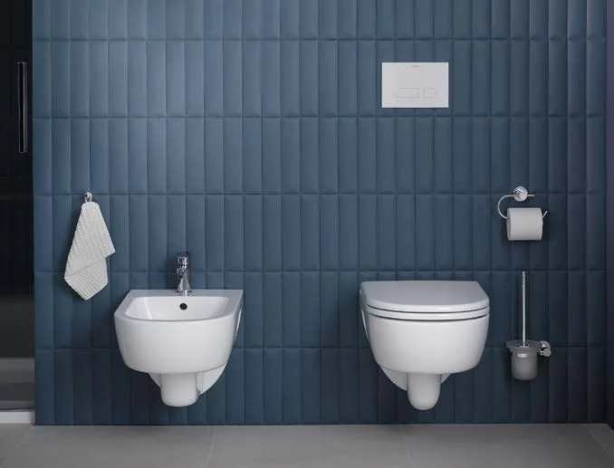 Bidet and toilet at a blue tiled wall