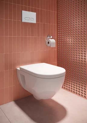 Toilet at a pink wall