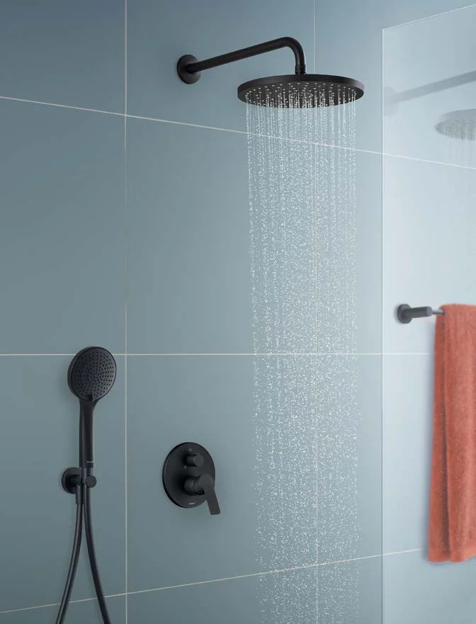 Black rain shower with running water at a light blue tiled wall