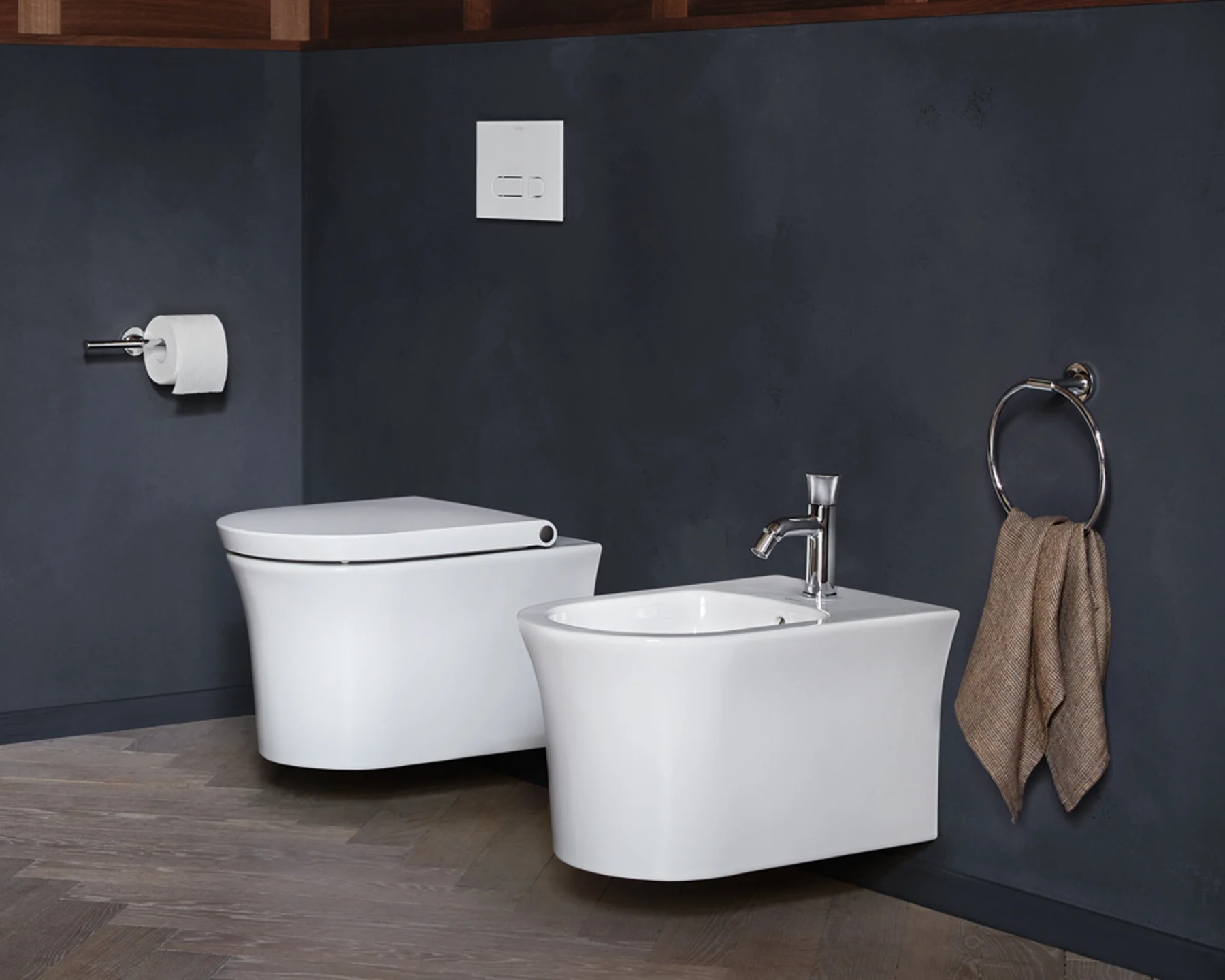 Wall hung toilet and bidet on a dark slate wall