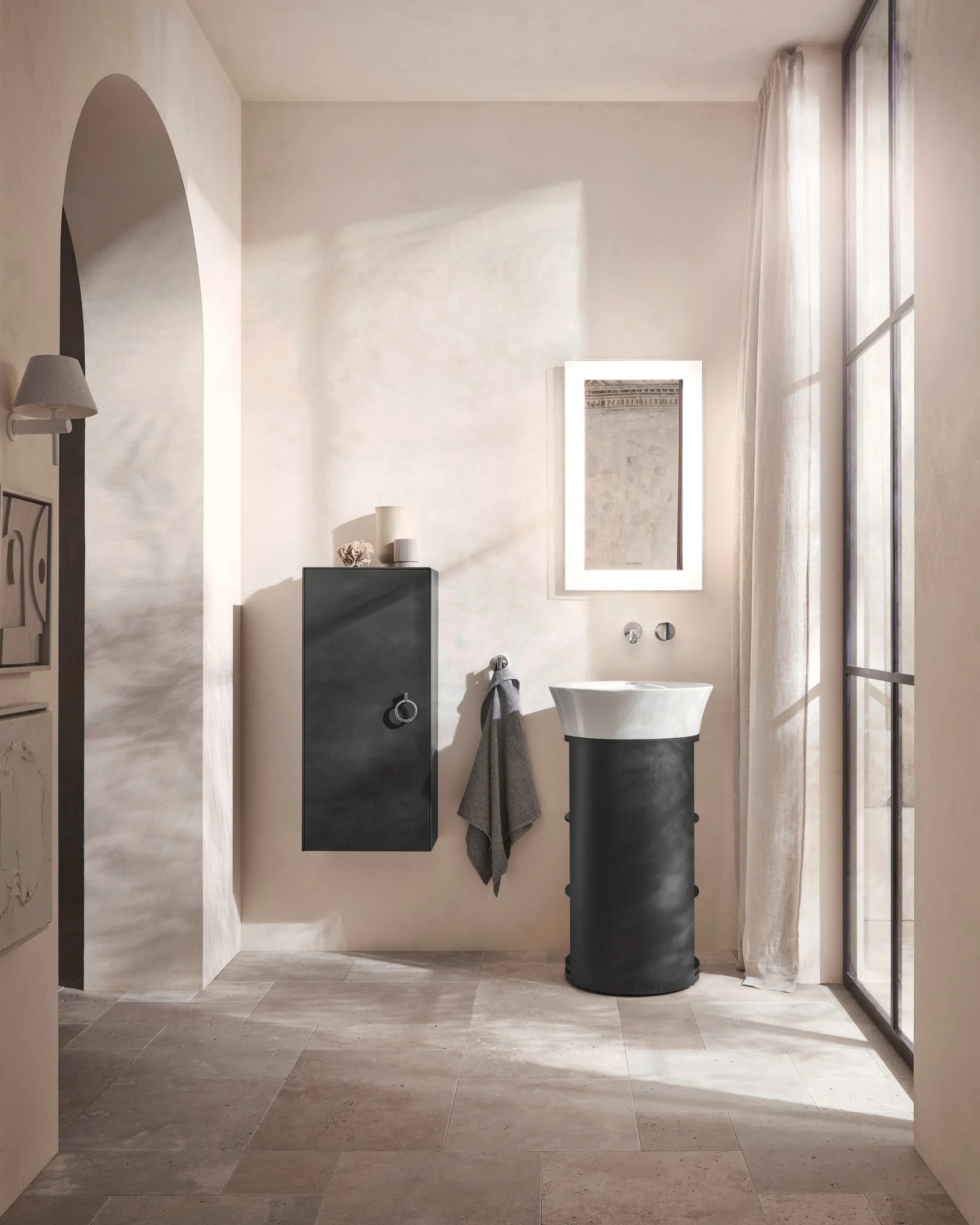Bathroom in warm plaster with a pedestal basin under an arched niche