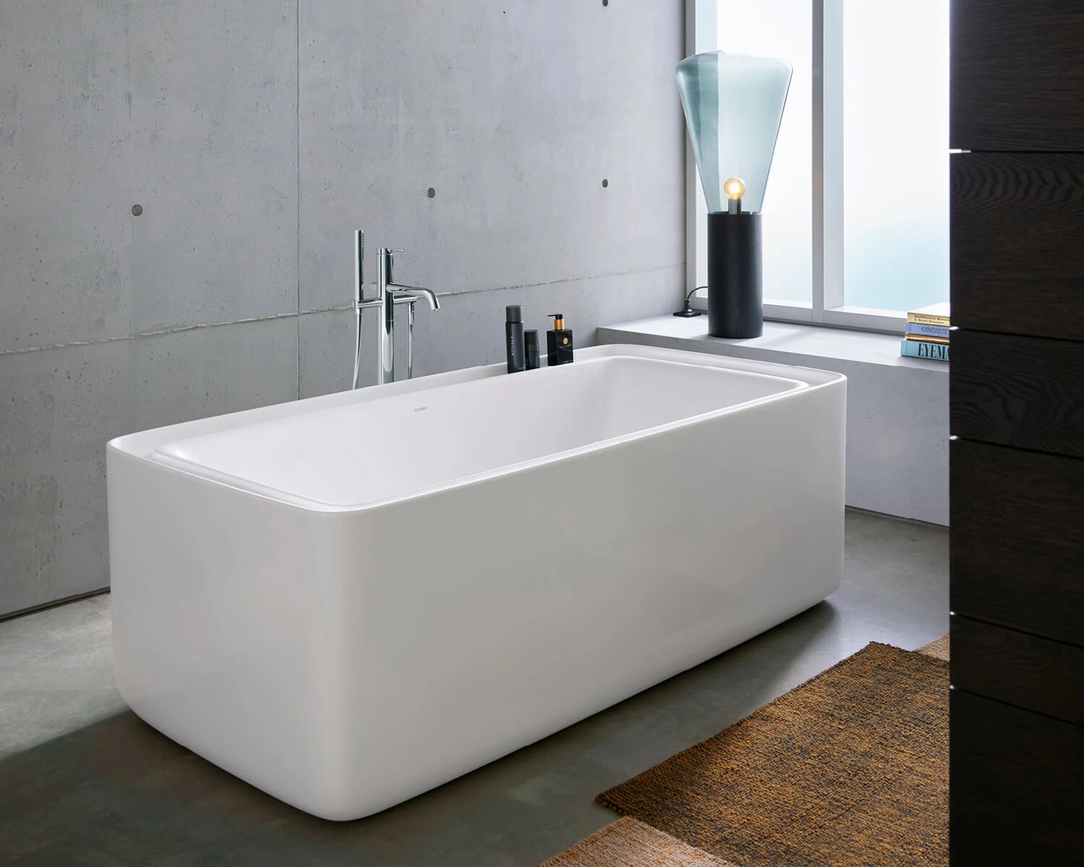 Freestanding bathtub in a concrete walled loft bathroom
