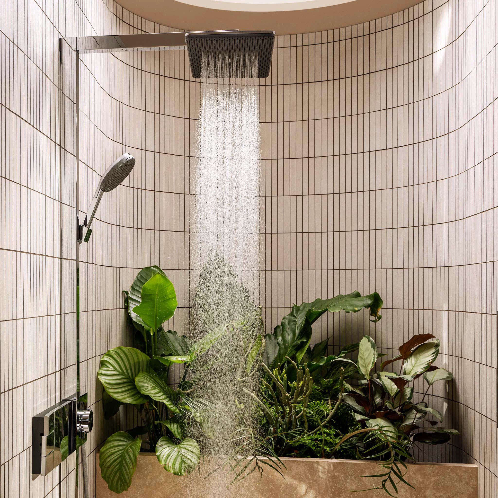 Round tiled rain shower niche with plants and a chrome hand shower