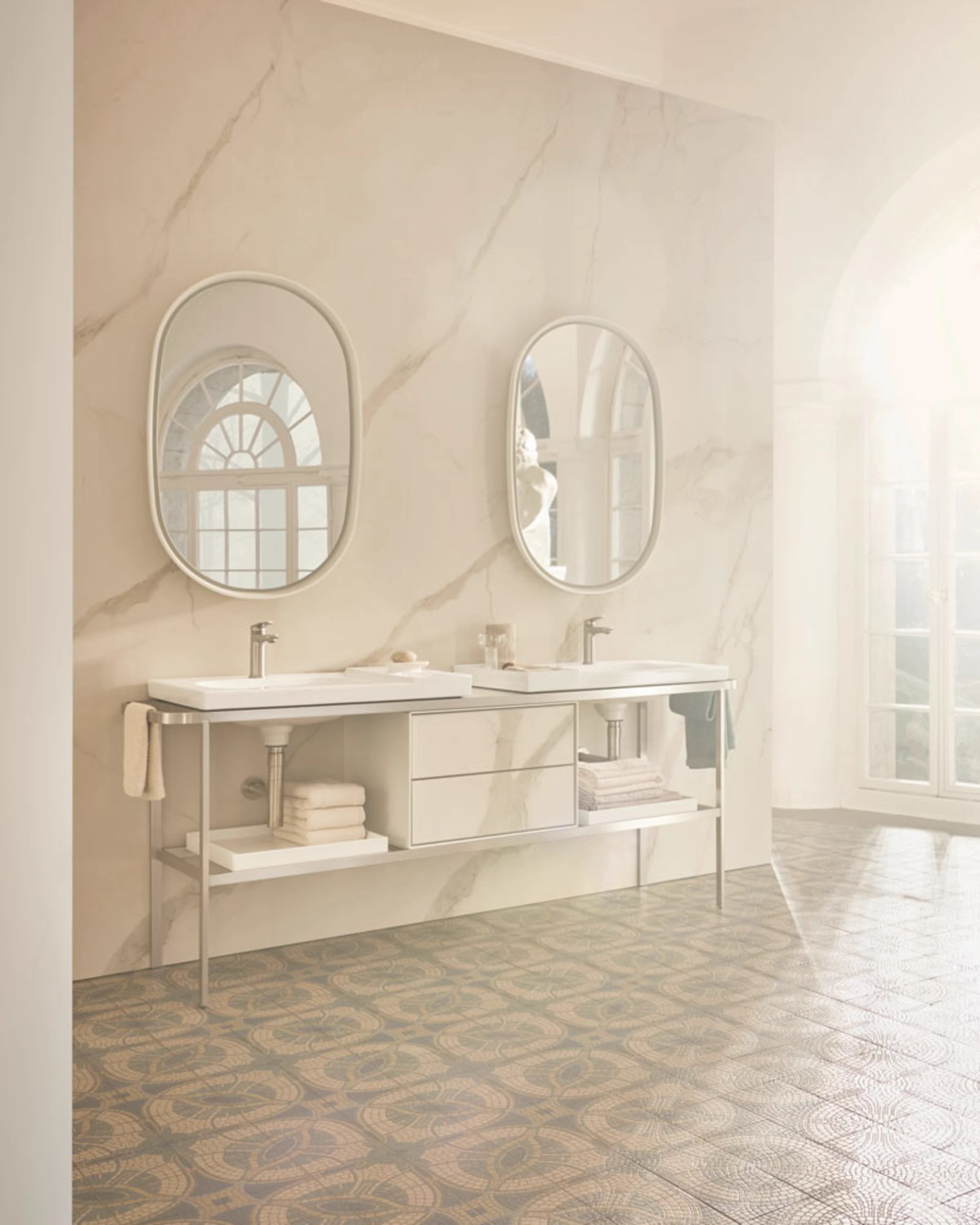 Aurena double washplace on a warm marble wall with oval mirrors