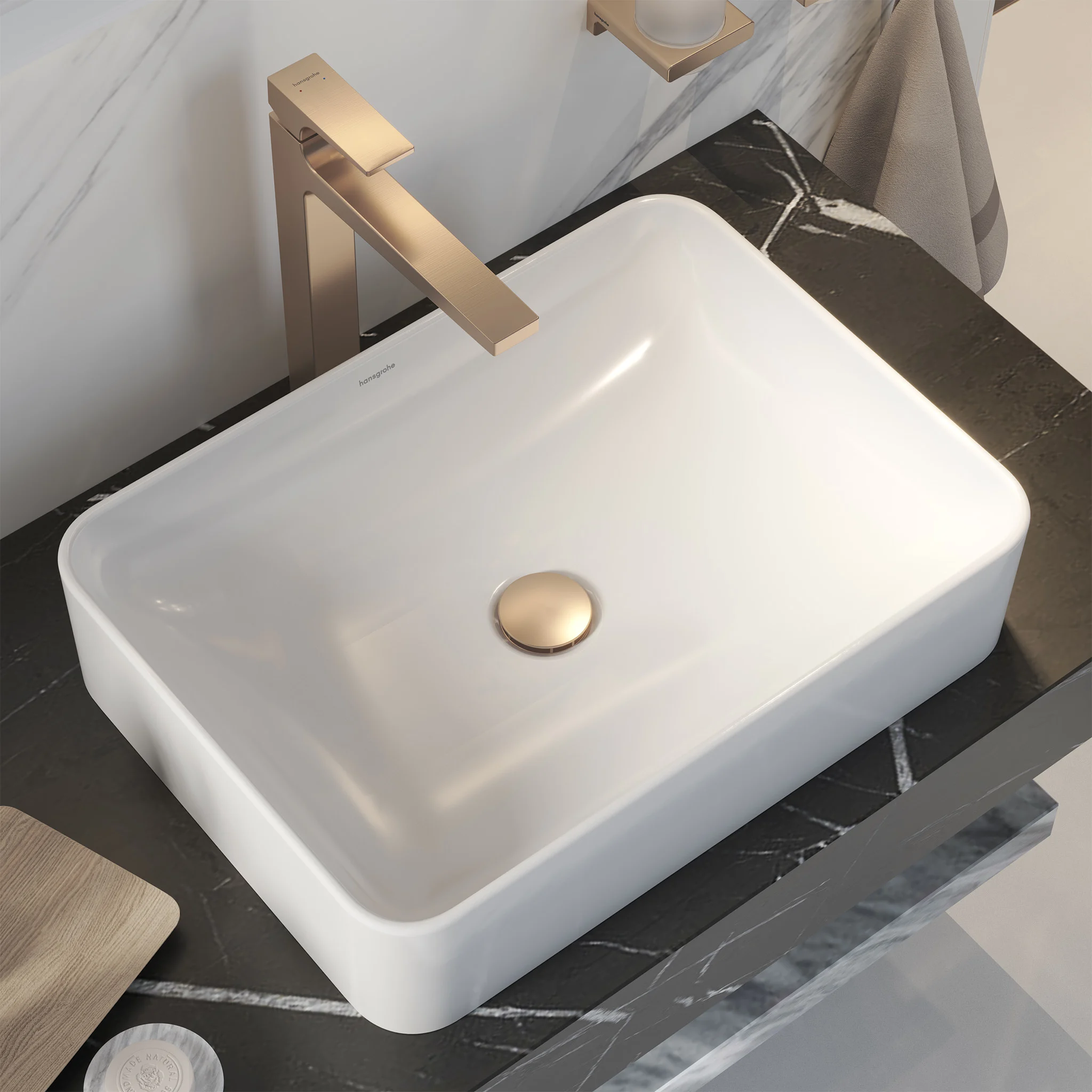 White basin on black marble with a bronze hansgrohe mixer