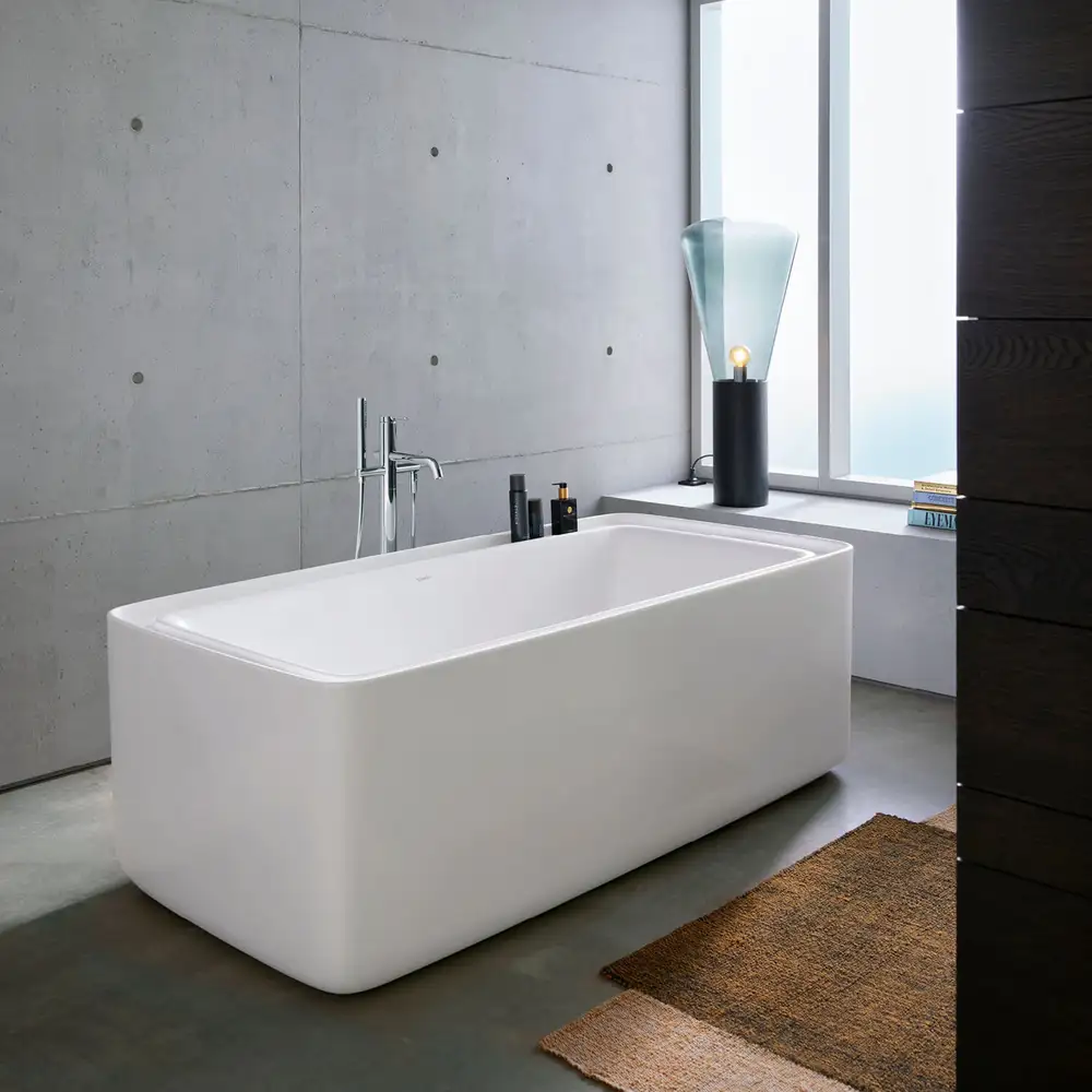 Bento Starck Box freestanding bath in a concrete room with a blue glass lamp