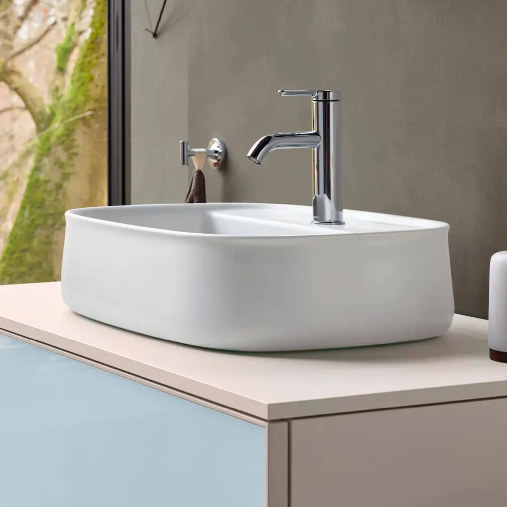 White bowl on a light vanity with a chrome mixer