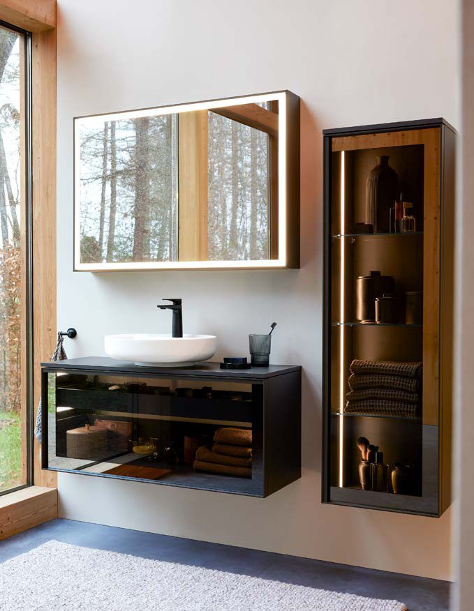 Vitrium vanity with a glass front and a lit display cabinet beside a window