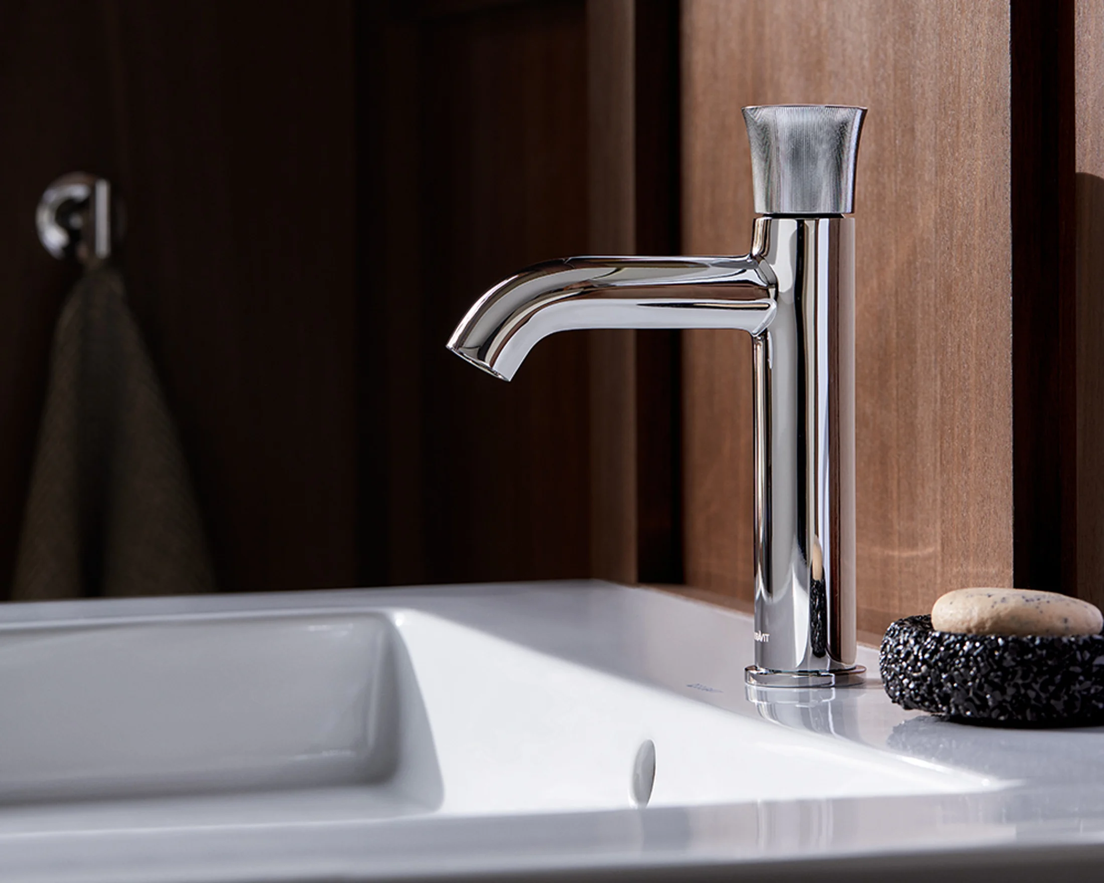 White Tulip chrome faucet on a washplace in front of walnut panelling